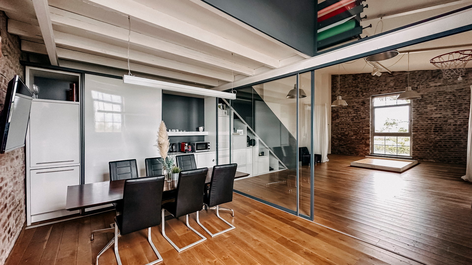 Helles Loftstudio in Neuss mit großen Industriefenstern, Glas-Meetingbereich und Tageslicht